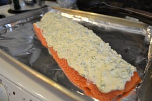 Spread the topping on the salmon.  It needn't go to the edge of the filet.
